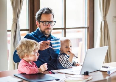 Mature man with a boy and girl working at home office